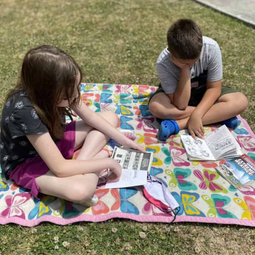 students reading independently outside on a blanket